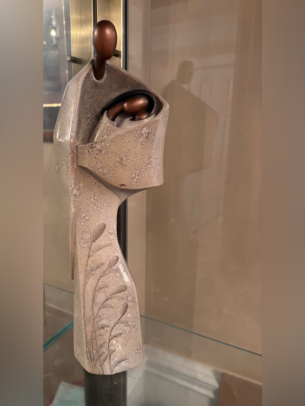 Resin reproduction of stylized faceless human figures in a family embrace